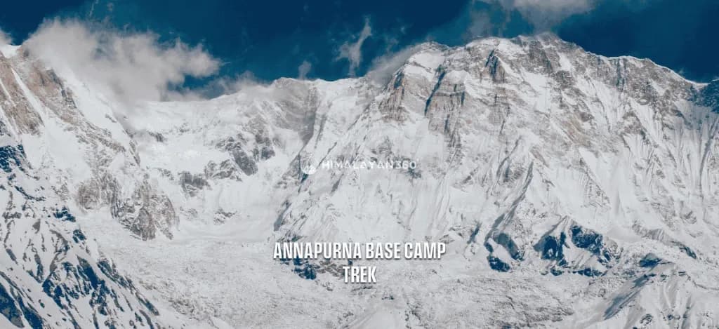 Snow capped Annapurna range with partial cloudy sky and a close-up view of peak mountains and glacier, text overlay saying "Annapurna Base Camp Trek" by Himalayan 360.
