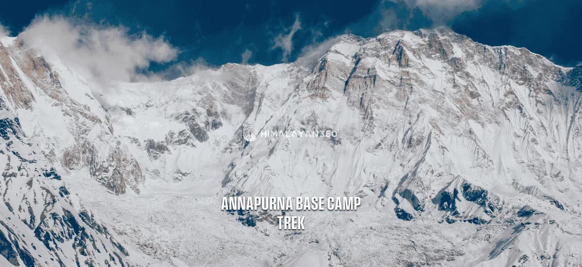 Snow capped Annapurna range with partial cloudy sky and a close-up view of peak mountains and glacier, text overlay saying "Annapurna Base Camp Trek" by Himalayan 360.