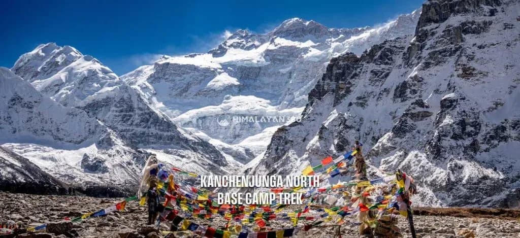 The Kanchenjunga North Base Camp with colorful prayer flags and Mount Kanchenjunga rising in the background.