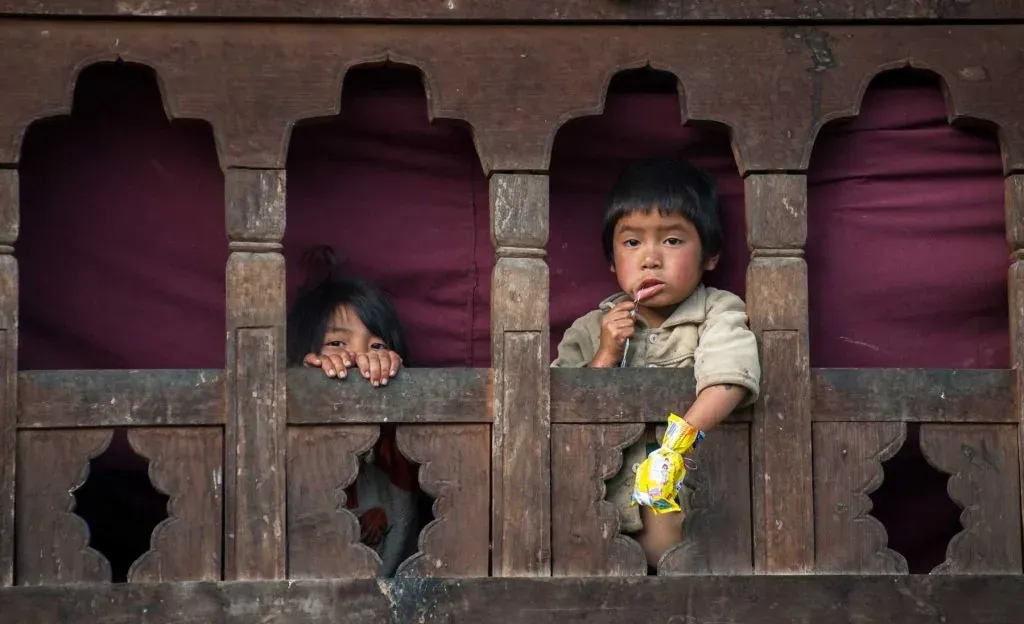 Kids looking out from window in Bhutan